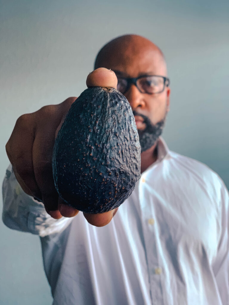 man holding avocado