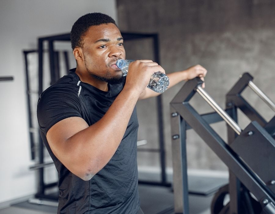 black man drinking water to hydrate during exercise